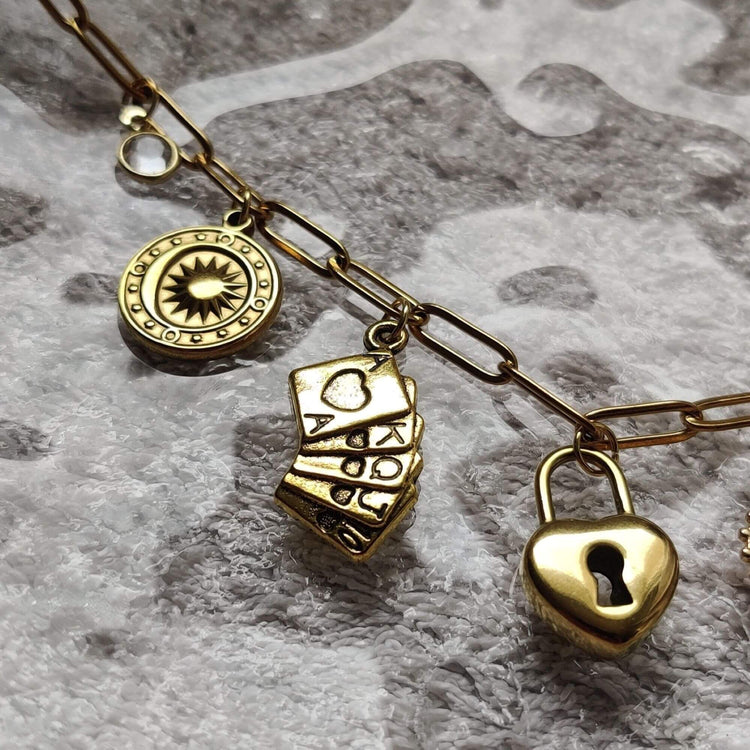 Zoom sur les charms du collier doré chance étoilée – soleil, jeu de cartes & cadenas – Roxy Paris
