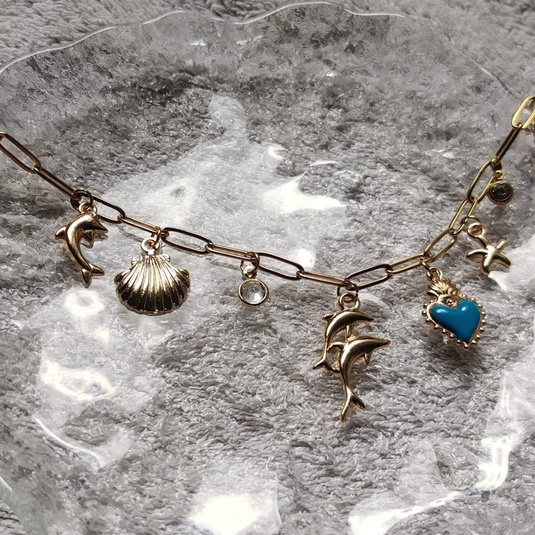 Collier Danse Océane doré avec charms coquillage, étoile de mer et dauphin fait main en France – bijou femme tendance Roxy Paris