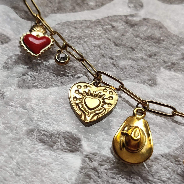 Zoom sur les charms rouges western porte-bonheur du collier doré - Roxy Paris