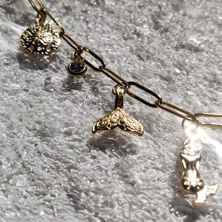 Zoom sur les charms coquillages, queue de sirène et & sirène du collier doré - Roxy Paris