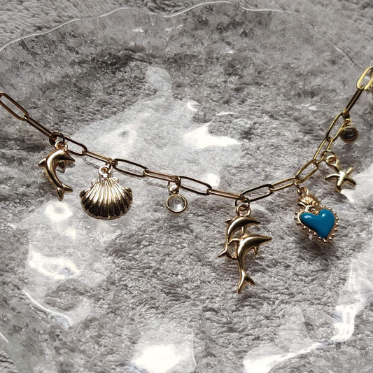 Collier Danse Océane doré avec charms coquillage, étoile de mer et dauphin fait main en France – bijou femme tendance Roxy Paris