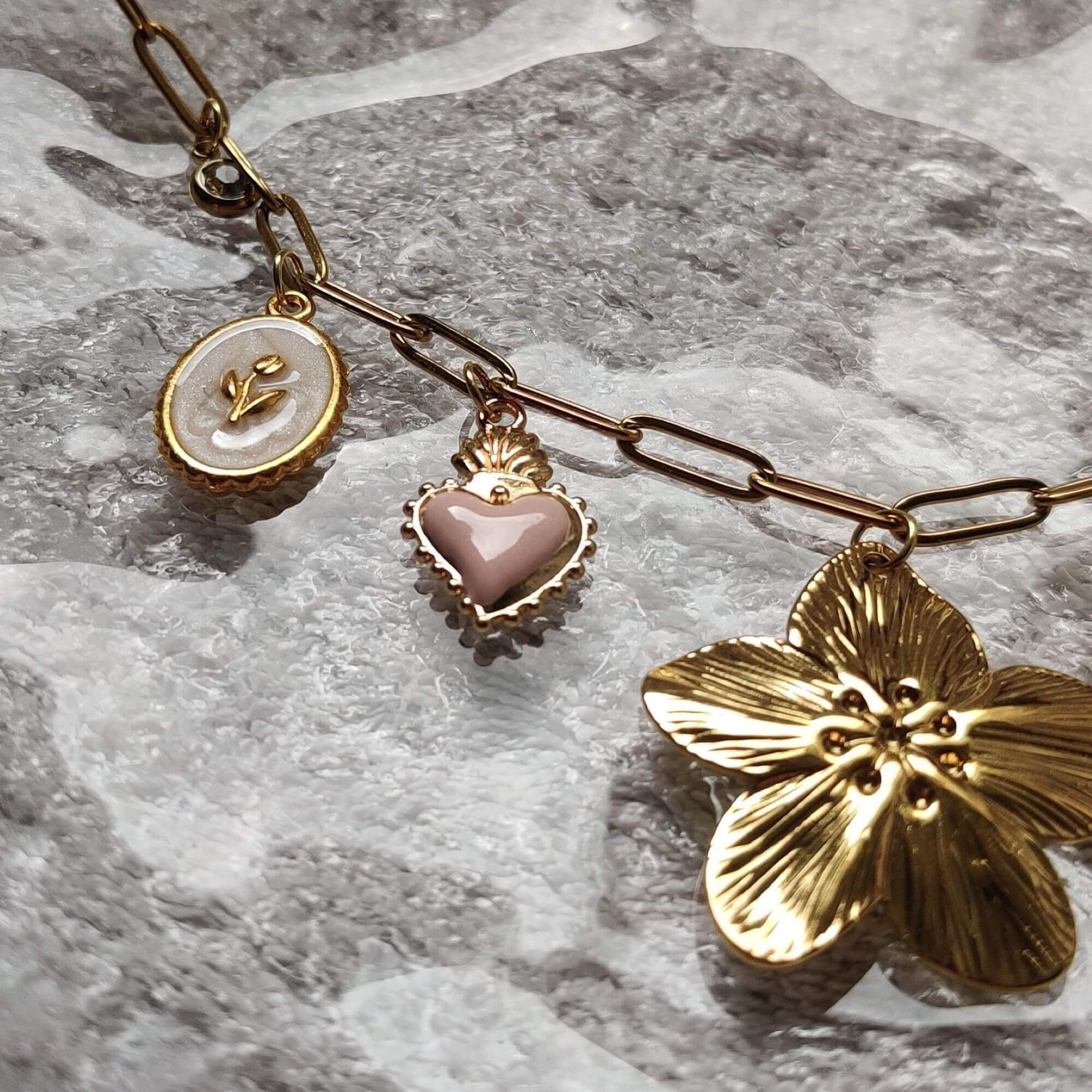 Zoom sur les charms du collier doré éclat floral – marguerite, coeur, fleur – Roxy Paris