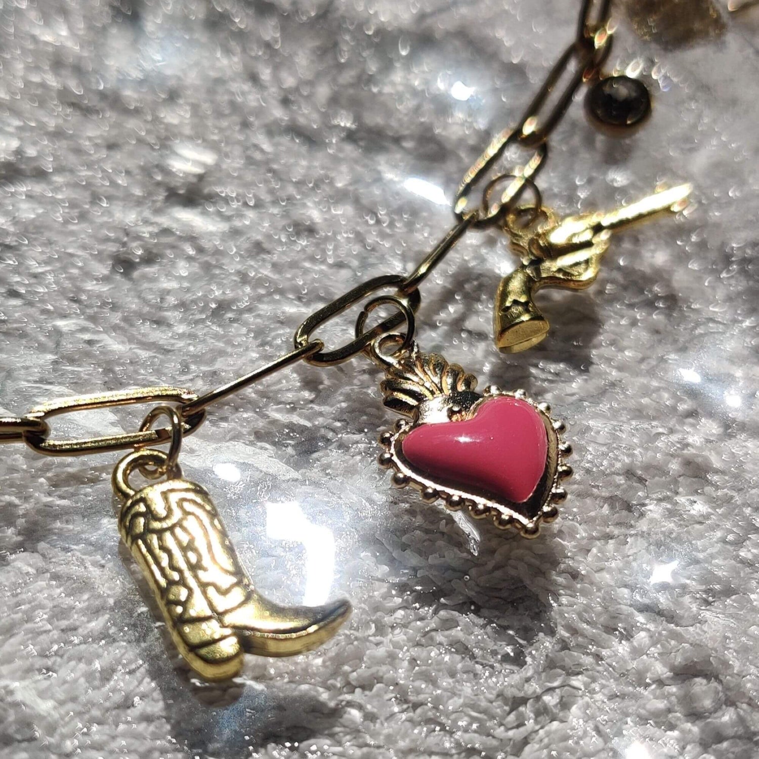 Zoom sur les charms western santiags pistolet du collier doré - Roxy Paris