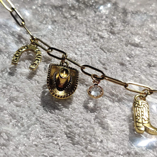 Zoom sur les charms western fer à cheval porte-bonheur du collier doré - Roxy Paris