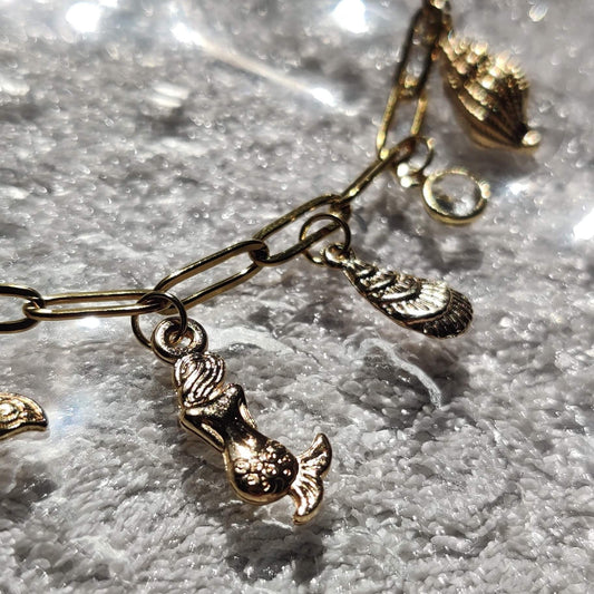 Zoom sur les charms Sirène & coquillage du collier doré - Roxy Paris